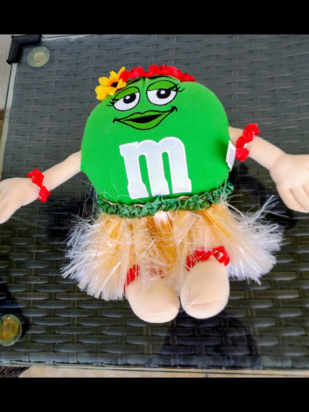 M&M'S Green Plush Hula Doll with Yellow Skirt and Red Flower Accents.Collectible